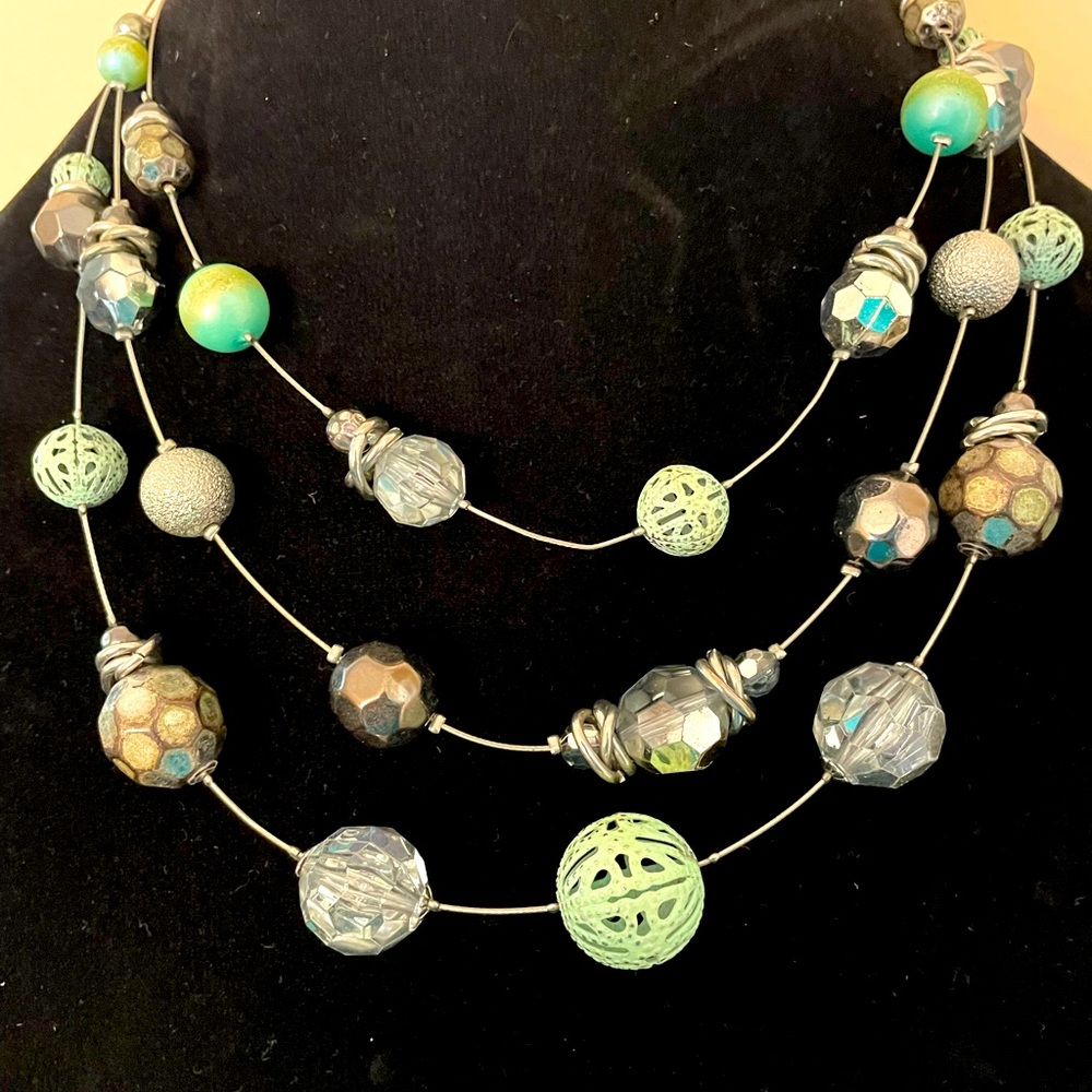 Multi strand metal necklace with station cutout green, silver, and crystal beads